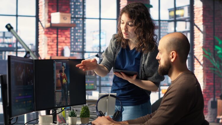 Man and woman collaborate on AI strategy content creation for the media industry, analyzing data and insights.